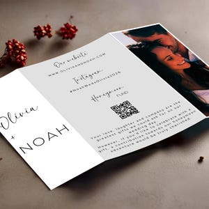 May include: A wedding invitation with a white background and black text. The invitation includes the couple's names, Olivia and Noah, their wedding website, Instagram hashtag, and a QR code for their honeymoon fund.