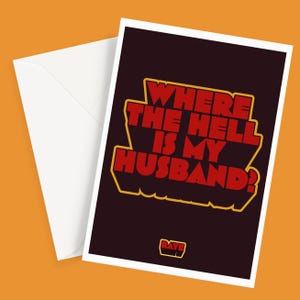 May include: A rectangular greeting card with a dark background and the red text WHERE THE HELL IS MY HUSBAND? outlined in yellow. A small logo with the text RAYE is at the bottom. A plain white envelope is positioned behind the greeting card.