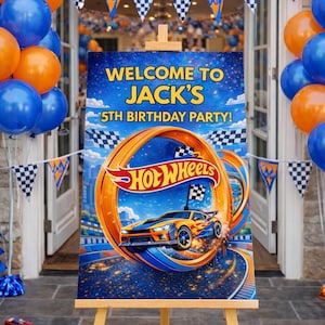 Può includere: Un cavalletto di legno espone un colorato cartello per la festa di compleanno a tema Hot Wheels. Il cartello recita "Benvenuti al 5° compleanno di Jack!" e presenta un design di auto da corsa. Palloncini blu e arancioni e bandiere a scacchi decorano lo sfondo.