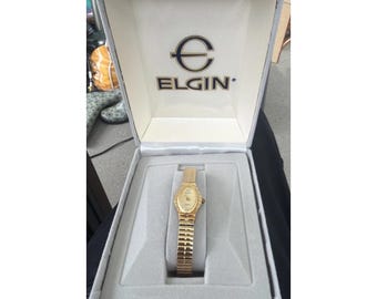 Orologio da donna vintage Elgin Diamond con quadrante ovale testurizzato e cinturino elastico color oro, NUOVO.