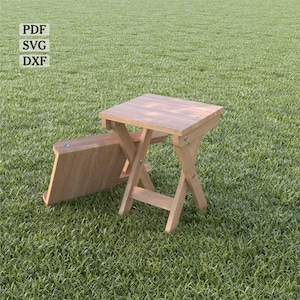 May include: Two wooden folding tables are displayed on a grassy surface. One table is fully assembled, while the other is partially folded. The tables are light brown and have a simple, rustic design. Text in the upper left corner reads "PDF SVG DXF".