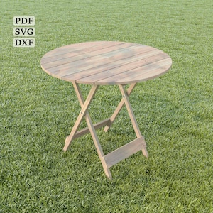 May include: A round wooden folding table with a natural wood finish. The table is set up on a green grassy lawn.