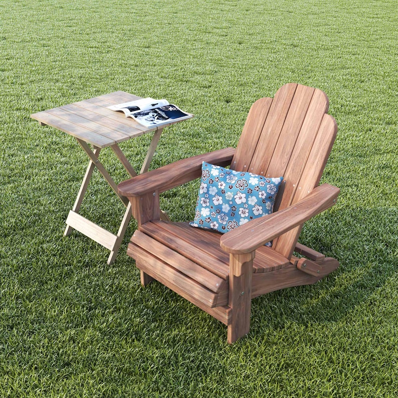 May include: A wooden adirondack chair with a blue and white floral pillow on a green grassy lawn. A small wooden folding table with a magazine on top is next to the chair.