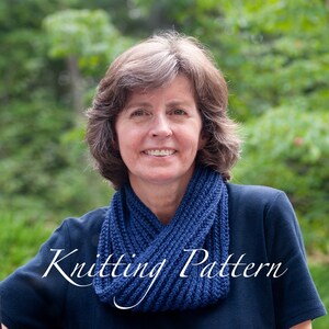 May include: A woman wearing a blue knitted cowl neck scarf. The scarf is made with a simple stitch pattern and has a relaxed, drapey look. Knitting Pattern.