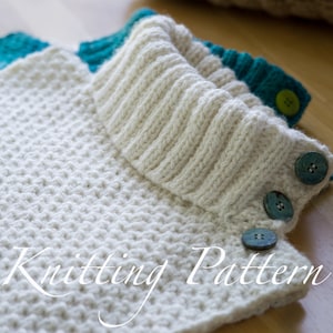 May include: White knitted cowl neck with a teal trim and three blue buttons. The cowl neck is folded over and the buttons are visible. The text "Knitting Pattern" is written on the cowl neck.
