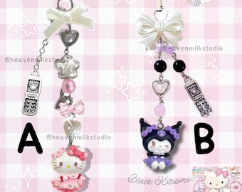 Puede incluir: Dos colgantes decorativos para teléfono. El colgante A presenta una figura de Hello Kitty con un vestido rosa, con lazos y corazones. El colgante B presenta una figura de Black Kuromi con un vestido morado, con detalles de cuentas negras. Ambos colgantes tienen un dije de teléfono plateado.