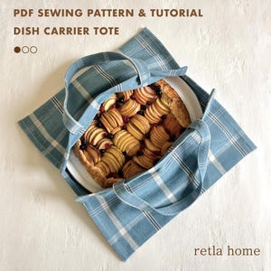 Könnte beinhalten: Eine blau-weiß karierte Geschirrtasche mit einem Kuchen mit geschnittenen Äpfeln. Die Tasche hat zwei Griffe und der Text "PDF SEWING PATTERN & TUTORIAL DISH CARRIER TOTE" steht oben. Der Markenname "retla home" steht unten.