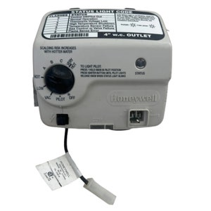 May include: A Honeywell gas control unit with a status light code and a control knob. The unit is gray with black text and a black control knob. It has a white connector and a label with text.