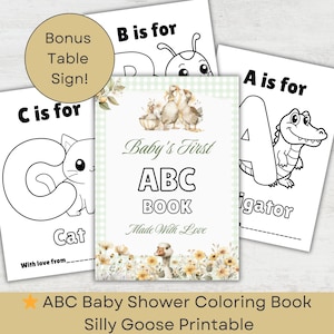 May include: A baby shower coloring book with the text "Baby's First ABC Book" and illustrations of animals and letters. The book includes a bonus table sign. The cover features a duck and floral design.