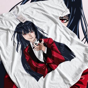 May include: White t-shirt featuring a detailed anime illustration. The graphic depicts a character with long black hair, red eyes, and a red suit. The character is pointing towards the viewer. A tag that says "LARGE" is attached to the shirt.