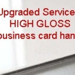 May include: White business card with the text "Upgraded Service HIGH GLOSS business card handling" printed in red.