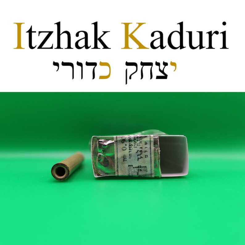 Puede incluir: La imagen presenta el texto "Itzhak Kaduri" en ingl&eacute;s y hebreo. Un objeto peque&ntilde;o y rectangular envuelto en papel y un objeto cil&iacute;ndrico est&aacute;n en primer plano sobre un fondo verde.