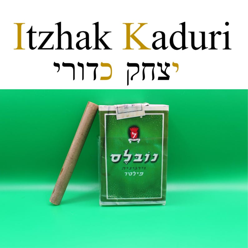 Puede incluir: Un paquete de cigarrillos verde y blanco con texto en hebreo y un cigarrillo marr&oacute;n apoyado contra &eacute;l. El texto "Itzhak Kaduri" se muestra encima del paquete en ingl&eacute;s y hebreo.
