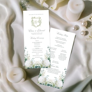以下が含まれることがあります： フローラルとグリーンのアクセントが施された2つの結婚式のプログラム。プログラムには「Clara & Edward」の名前と結婚式の詳細が記載されています。白いキャンドルと真珠も存在します。