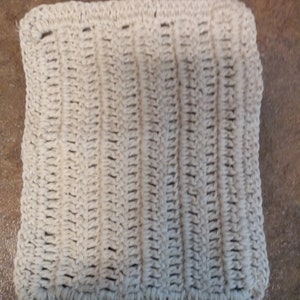 May include: A white crocheted dishcloth with a textured pattern.