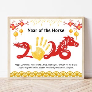 以下が含まれることがあります： 「Year of the Horse」の文字と、赤と黄色で「2026」の数字が描かれた額入りのプリント。赤い馬のシルエット、黄色の手形、お祝いの装飾が施され、「Happy Lunar New Year」の文字も含まれています。