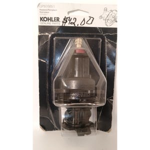 May include: A Kohler genuine parts replacement cartridge, model GP876851, in a clear plastic package. The cartridge is black with a brass fitting and a red seal. The packaging includes the Kohler logo and product information.