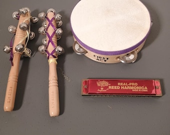 Juego de instrumentos para niños del primer acto: pandereta, palos de cascabel y armónica.