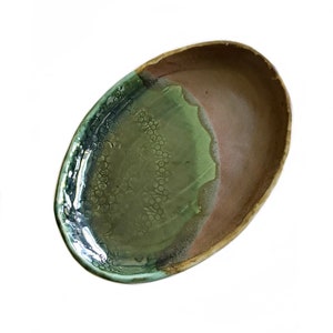 May include: A green and brown oval ceramic serving dish with a textured glaze.