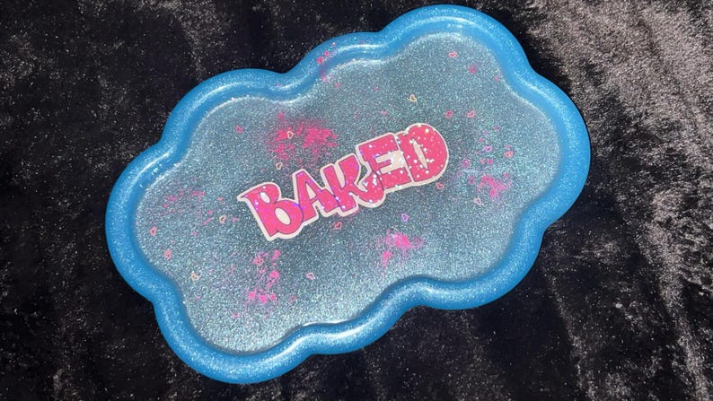 May include: A cloud-shaped tray with a glittery blue surface and a bright blue rim. The tray has pink accents and the word "BAKED" in pink and white lettering.
