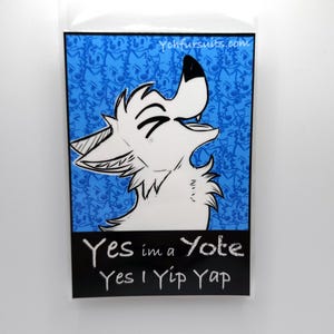 May include: A white cartoon wolf with a blue background. The wolf is howling and has a happy expression. The text "Yes i'm a Yote Yes I Yip Yap" is written in white on a black background.