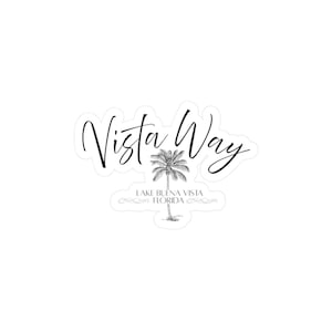 May include: A white sticker with the words "Vista Way" in a cursive font. Below the text is a detailed illustration of a palm tree. The text "Lake Buena Vista Florida" is below the palm tree in a smaller font.