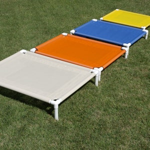 May include: Four elevated pet beds in different colors: beige, orange, blue, and yellow. The beds are made of a sturdy metal frame and a breathable fabric.