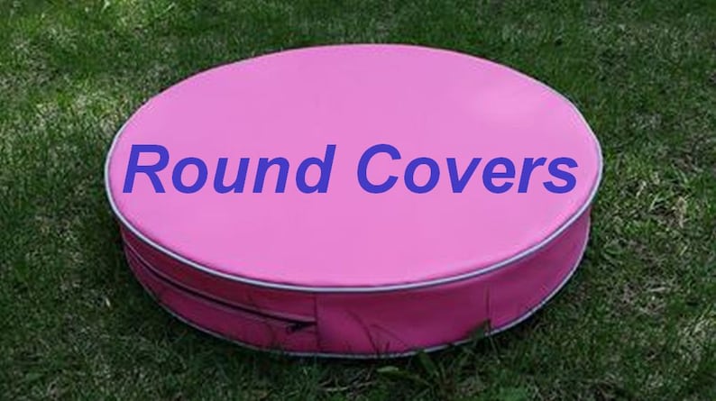 May include: A round, pink cover with the text "Round Covers" in blue. The cover has a white trim and a zipper closure. The cover is sitting on green grass.