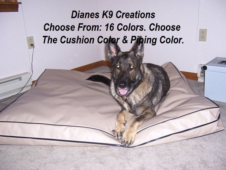 May include: A German Shepherd dog lying on a beige dog bed with black piping. The bed is on a light grey carpet. The text "Dianes K9 Creations Choose From: 16 Colors. Choose The Cushion Color & Piping Color." is visible above the dog.