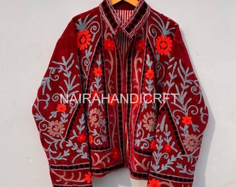 May include: A burgundy jacket with intricate floral embroidery in red, gray, and black. The jacket features a collared neckline and is open in the front. The text "NAIRAHANDICRAFT" is visible on the jacket.