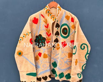 May include: Beige jacket with colorful floral embroidery. The jacket features red, green, and yellow embroidered flowers, leaves, and heart shapes. The text "NAIRAHANDICRAFT" is visible on the front of the jacket.