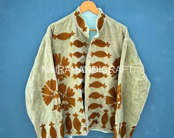 May include: A light green jacket with brown floral embroidery and a striped lining. The jacket is hanging on a wooden hanger against a blue background. The text "NAIRA HANDICRAFT" is visible on the jacket.