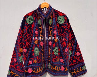 May include: A navy blue velvet jacket with intricate floral embroidery in red, green, yellow, and pink. The jacket features a mandarin collar and is embellished with the text "nairahandicrft".