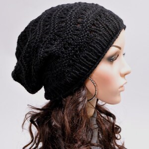 May include: A black knitted beanie with a slouchy fit. The beanie is made of a soft, comfortable yarn and has a simple, stylish design.