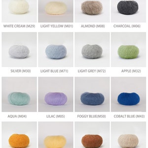 May include: A color chart of yarn samples, showing 24 different colors of yarn. The yarn is arranged in a grid of 4 rows and 6 columns. Each yarn sample is a small ball of yarn, and the color name and code are printed below each sample.