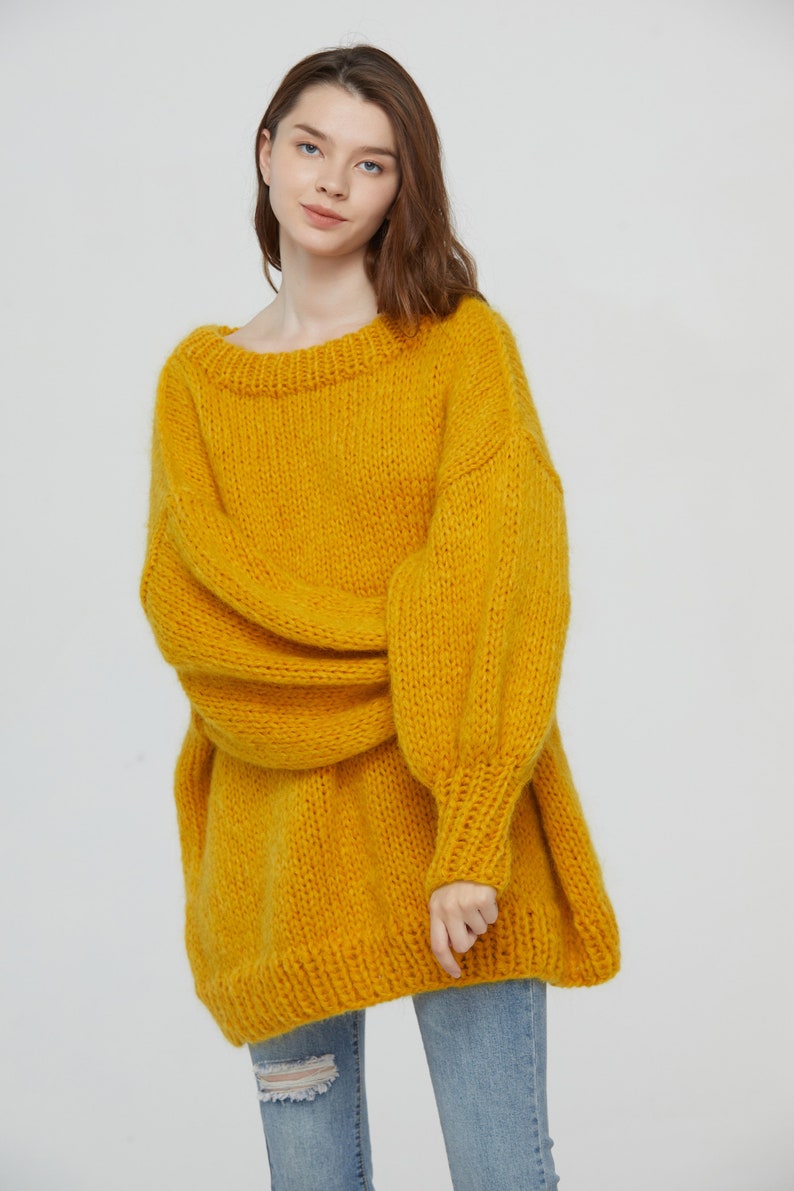 K&ouml;nnte beinhalten: Ein locker sitzender, &uuml;bergro&szlig;er gelber Strickpullover mit langen &Auml;rmeln und einem runden Ausschnitt.