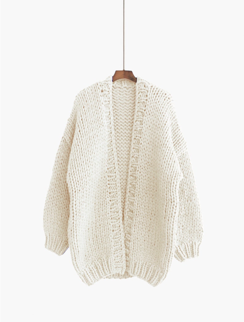 K&ouml;nnte beinhalten: Ein cremefarbener Strickcardigan mit langem, offenem Vorderteil und langen &Auml;rmeln.