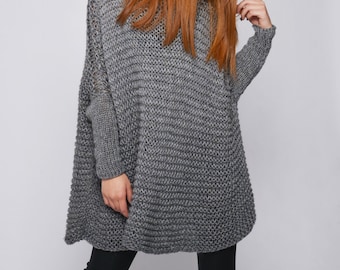 May include: A gray oversized knitted sweater with a loose fit and long sleeves.