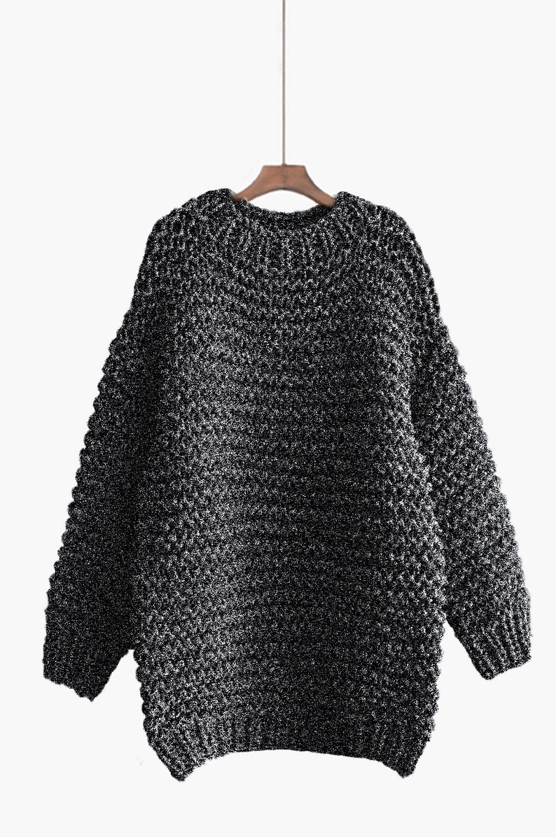 May include: A black and silver chunky knit sweater with a round neckline.