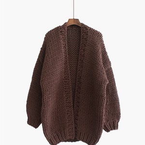 K&ouml;nnte beinhalten: Ein brauner, grob gestrickter Cardigan mit langen &Auml;rmeln und offenem Vorderteil.