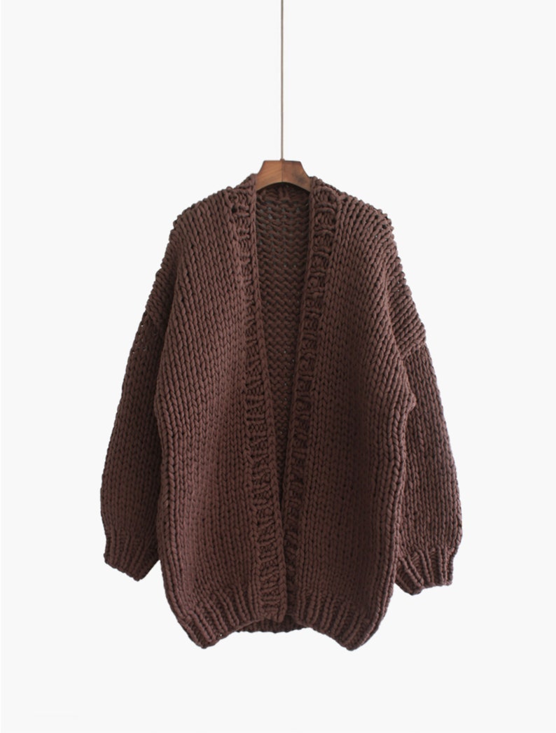 K&ouml;nnte beinhalten: Ein brauner, grob gestrickter Cardigan mit langen &Auml;rmeln und offenem Vorderteil.
