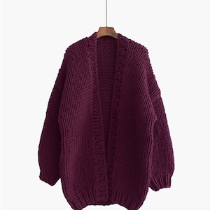 K&ouml;nnte beinhalten: Ein tief burgunderfarbener Strickcardigan mit einem langen, offenen Vorderteil und langen &Auml;rmeln.