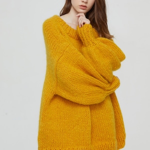 K&ouml;nnte beinhalten: Ein gelber, &uuml;bergro&szlig;er Strickpullover mit lockerer Passform und langen &Auml;rmeln.