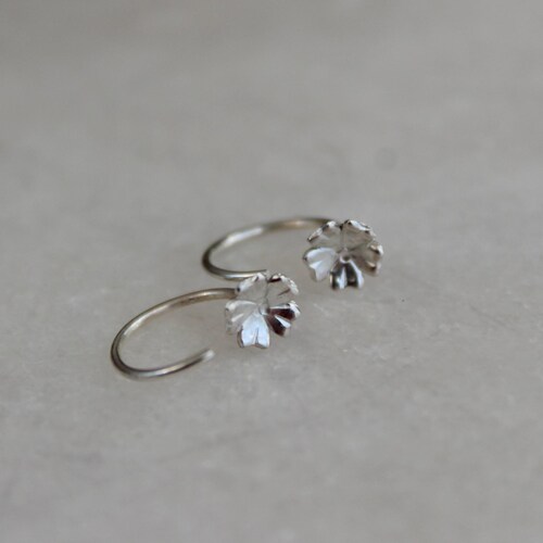 Pendientes de aro pequeños con forma de flor de plata esterlina, estilo minimalista.