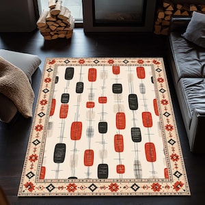 May include: Rectangular area rug with a cream background and a repeating pattern of red and black oblong shapes. The rug has a decorative border with floral and geometric designs. The rug is placed on a dark wood floor.