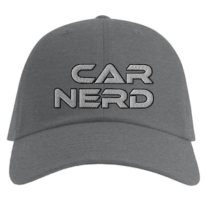 Op de afbeelding: Een grijze baseballcap met de geborduurde tekst "CAR NERD" in zilver. De pet heeft een gebogen klep en een stoffen bandsluiting aan de achterkant. Gemaakt van een zacht, duurzaam materiaal.