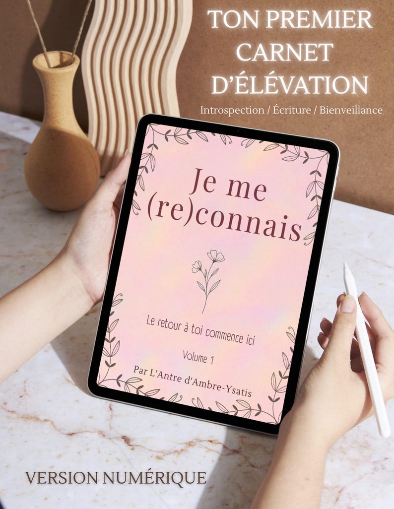 Op de afbeelding: Een digitale tablet met een roze journal cover met de tekst "Je me (re)connais" en bloemmotieven. De tablet wordt door een persoon vastgehouden, met een stylus. De bovenste tekst luidt "TON PREMIER CARNET D'&Eacute;L&Eacute;VATION".