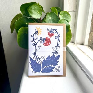 Tarjeta de felicitación con diseño de fresa, interior en blanco con sobre de papel kraft.