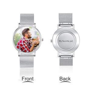 May include: A silver wristwatch with a mesh band. The watch face displays a photo of a person with a dog. The back of the watch is silver and has the text "My favorite pet".