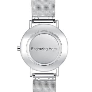 May include: A silver wristwatch with a mesh band and a round face. The watch face has the text "Engraving Here" in black. The watch has a minimalist design.